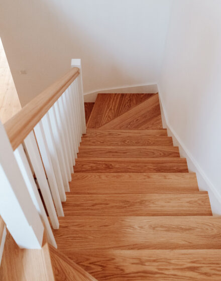 Subalansuotas interjeras: grindys, durys, net turėklai laiptais sumaniai suderinti tarpusavyje